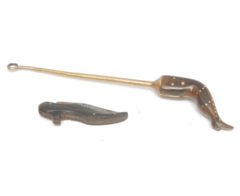 An Art Deco style novelty pen-knife, the ebonised handle as a high-heeled shoe, 13cm long overall; a novelty brass button hoo