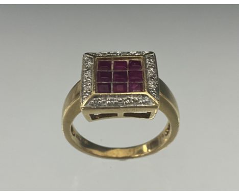 A ruby and diamond ring, central cluster of nine red emerald cut rubies within round brilliant cut diamond accented shoulders