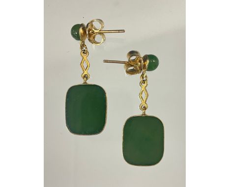 A pair of green stone possibly jade and yellow metal drop earrings, each with rounded rectangular flecked green and black pan