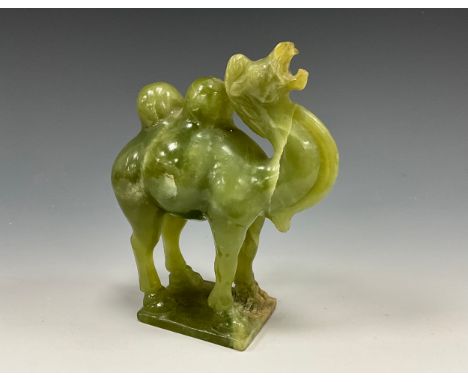 A Chinese spinach jade carving, of a Bactrian camel, statant with rearing head, rectangular base, 15.5cm high overall