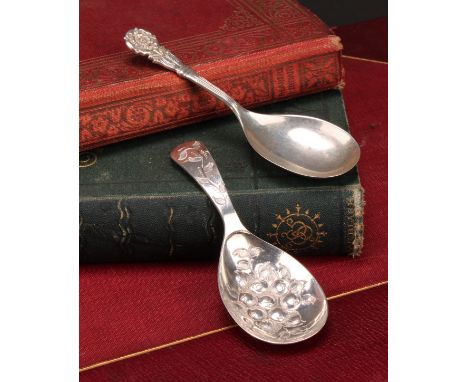 A George III style silver caddy spoon, the bowl chased with fruiting foliage, 9.5cm long, Birmingham 1964; another, Tudor ros