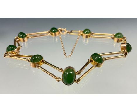 A jade cabochon yellow metal bracelet, two bar links, divided by nine oval cabochons, indistinctly marked to clasp, 19cm long