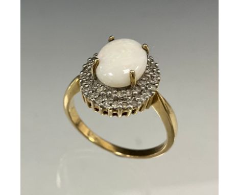 A diamond and opal cluster ring, central oval opal cabochon, red green and violet colours, surrounded a two layer halo of rou