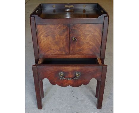 An early 19th Century mahogany tray top night Commode with pierced gallery covered under, enclosed by a pair of panel doors a