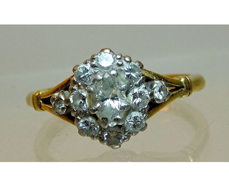 An 18ct. gold Dress Ring with a marquise cut centre diamond surrounded by smaller diamonds.