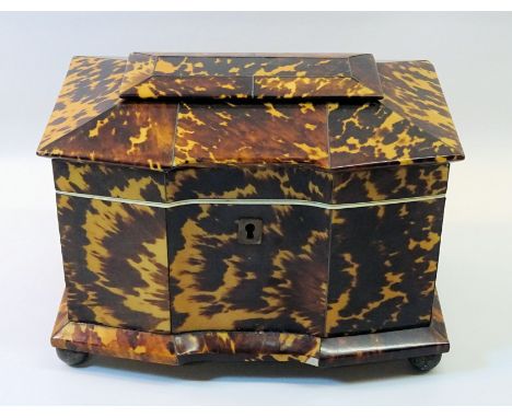 An early 19th Century tortoise shell Tea Caddy of sarcophagus design, with hinged lid, the interior fitted with two covered c