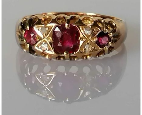A Victorian ruby and diamond ring in a gallery setting, the largest ruby 6mm diameter, two others 2.5mm with four old-cut dia