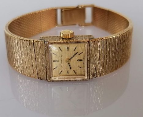A vintage Longines ladies dress watch with baton markers, signed to face and on Swiss mechanism, 9ct yellow gold bark-effect 