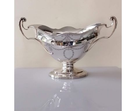 An Edwardian silver two-handled oval bowl with wavy rim, reeded borders and etched neo-classical motifs on a raised foot by J