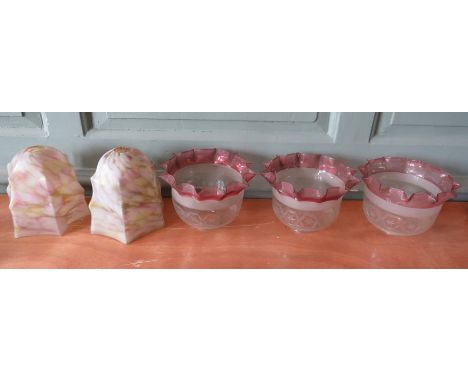 A pair of multi-coloured Victorian glass lamp shades, together with a set of three oil lamp shades with pink rim in a hankerc