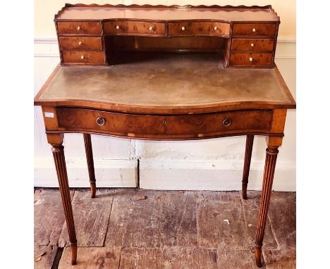 A Sheraton revival mahogany desk, circa 1910, three quarter gallery top on an arrangement of desk drawers in serpentine form 