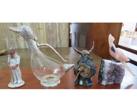 A mixed group of: a ceramic figure or a cricketer, a ceramic figure of a Viking, a wine curafe modeled as a duck and a parrot