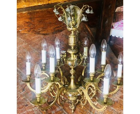 A 20th Century brass six branch chandelier, two lights fitted to each scrolling foliage branch in manner of lit candles, moun