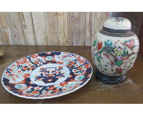 Two twentieth century oriental ceramic items: a large charger, 43cm wide and a lidded jar on a stand. (2)