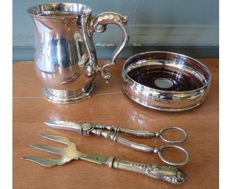 A hallmarked silver mug and a hallmarked silver bottle coaster with mahogany insert together with an EPNS fork and tongs. (4)