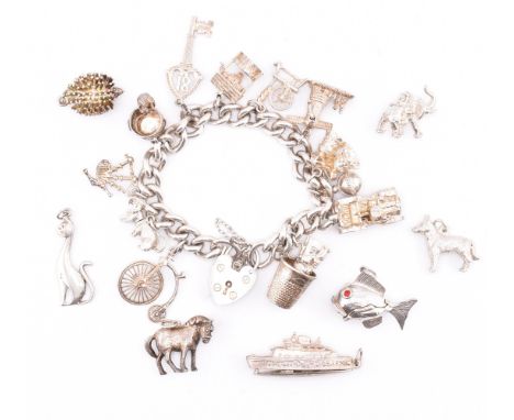 A silver charm bracelet and assorted silver charms. A hallmarked silver curb link chain bracelet with a hallmarked heart padl
