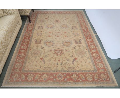 A modern light ground rug, 270cm x 188cm and a peach ground floral wool rug, 277cm x 185cm Condition Report: The light ground