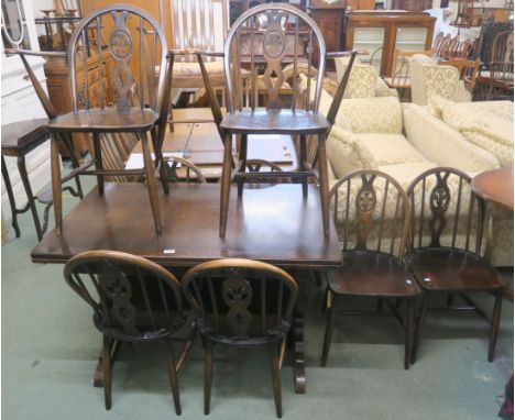 A dark Ercol refectory extending dining table, 74cm high x 166cm wide x 71cm deep with four fleur de lys chairs and two carve