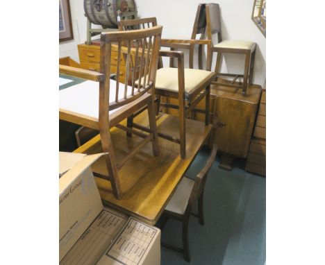 A walnut dining suite comprising extending dining table, 77cm high x 167cm wide x 78cm deep with two carvers and four Ercol  