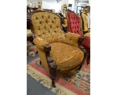A Victorian carved mahogany framed, button upholstered armchair.
