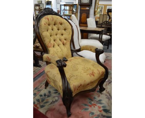 A Victorian button upholstered mahogany framed open armchair.