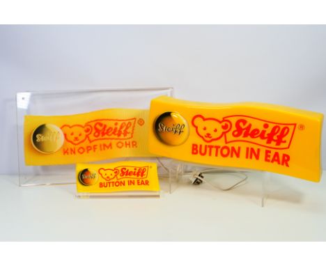 Steiff - A collection of Steiff shop display items, a light up yellow wall mounted sign in the form of a Steiff tag, it measu