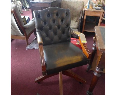 A button back leather style captains swivel chair, raised on castors 
