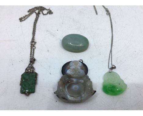 A collection of four jade items to include two jade pendants and a carved jade buddha and similar. (4)