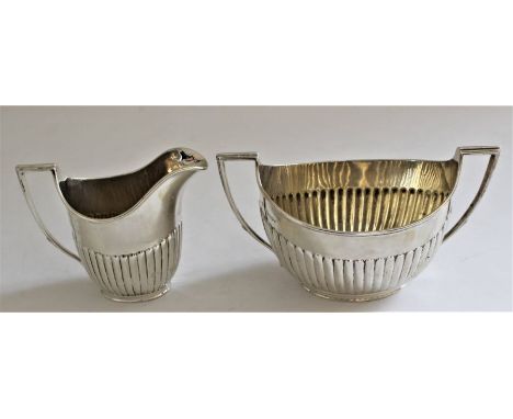 A Victorian silver twin-handled partly fluted oval sugar basin, 9.5cm high and matching cream jug with reeded handles by Walt