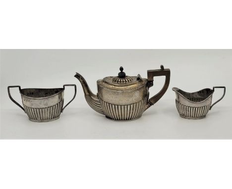 A silver three piece bachelors tea service, by John Edward Wilmot, Birmingham 1904, of oval semi-fluted form. (3). (gross wei