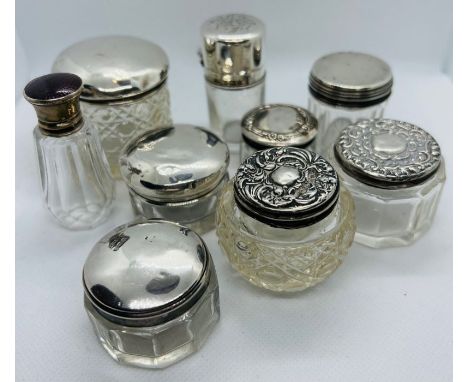 A collection of silver lidded cosmetics pots. Featuring a guilloche enamel lidded bottle, marked for Henry Perkins &amp; Sons