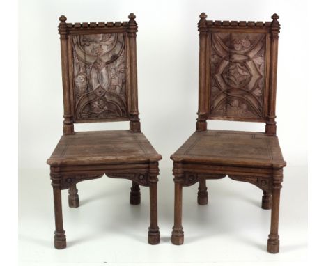A pair of 19th Century carved oak Hall or Architectural Chairs, in the style of Pugin, the panel backs carved in relief in th