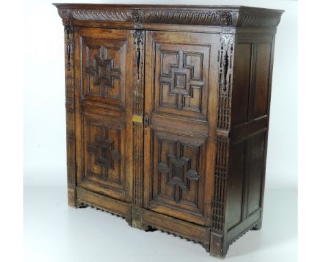 A late 18th / early 19th Century carved oak Cupboard, the cornice with lion mask heads, over two large doors each with double