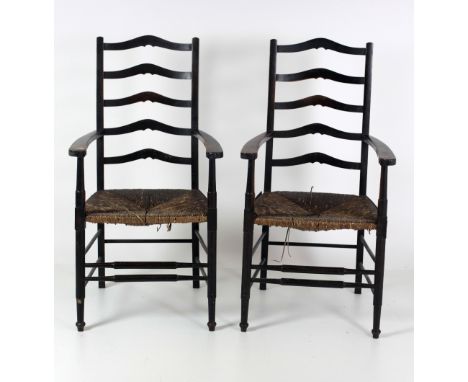 A pair of attractive Arts & Crafts period ladder back Armchairs, with cane work seats and multiple stretcher supports on turn