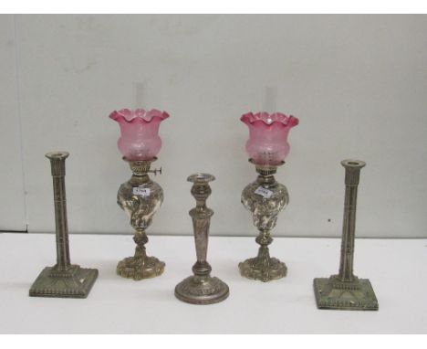 Two Oil Lamps, with ruby glass shades, with a collection of seven Candlesticks, as a lot. (9)