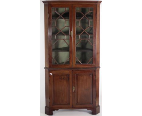 An Irish Georgian mahogany Corner Cabinet, of large proportions, moulded cornice, astragal glazed doors, on a base with two p