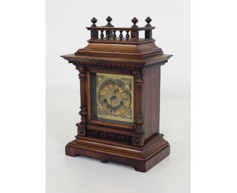 An Edwardian oak Mantle Clock, with gallery top, over glazed door with brass dial and Roman numerals, flanked by half reeded 