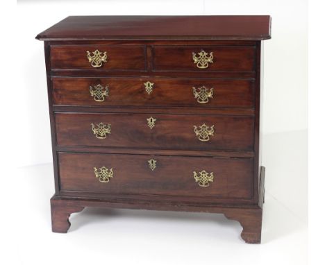 A Georgian mahogany Chest of drawers, the plain shaped and moulded top (later) over two short and three long drawers with att