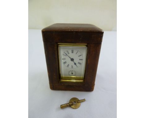 A brass alarm carriage clock of customary form in original leather case