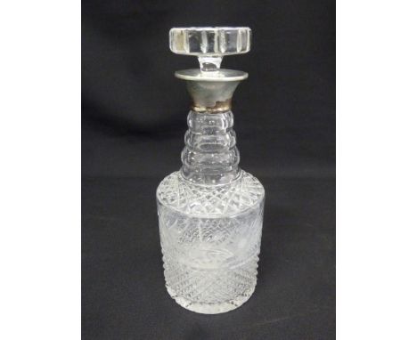 A cut glass decanter with drop stopper and plain silver collar