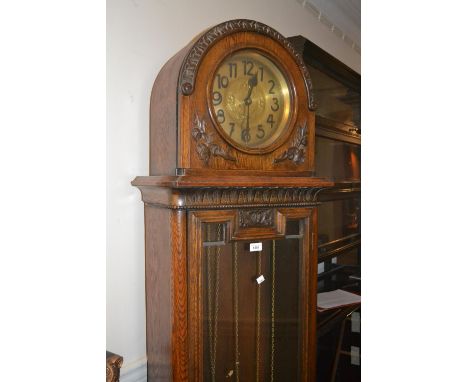 Early 20th Century carved oak longcase clock, the dome hood above a circular dial and moulded glazed panelled door raised on 