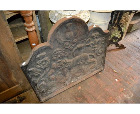 Cast iron fire back decorated in high relief with a lion (at fault), a fire grate, dogs, kerb and tools 