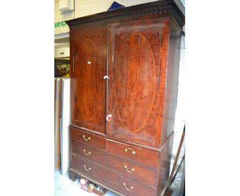 19th Century mahogany linen press having a moulded cornice above two flush panelled oval crossbanded doors fitted with two sl