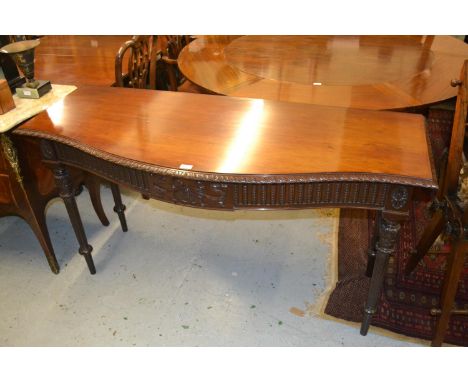 Mahogany serpentine shaped side table in Adam style, the gadroon moulded top above a carved and moulded frieze on turned tape