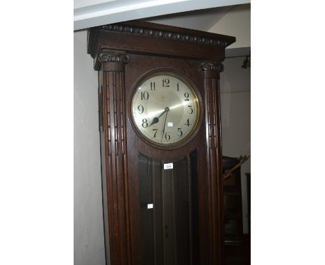 Oak longcase clock circa 1930, the rectangular case with flanking pilasters, the circular silvered dial with Arabic numerals 