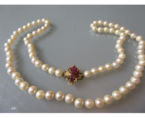 Uniform cultured pearl necklace with a 14ct gold ruby set clasp 