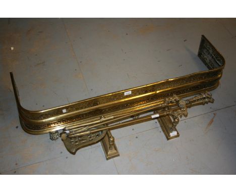 19th Century pierced brass fender on paw supports together with various fire tools etc 