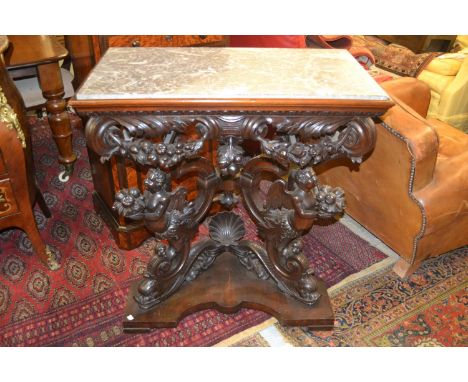 19th Century Italian walnut console table having grey flecked marble top, above a heavily carved frieze on shaped shell dolph