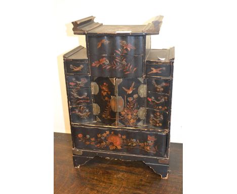 Oriental black lacquered bird, floral and gilt decorated table cabinet having multiple drawers around a central cupboard, on 