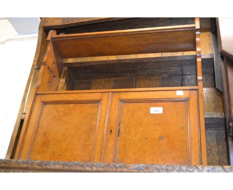 Late Victorian oak wall bracket with open shelves above two panel doors and Gothic style pierced sides 